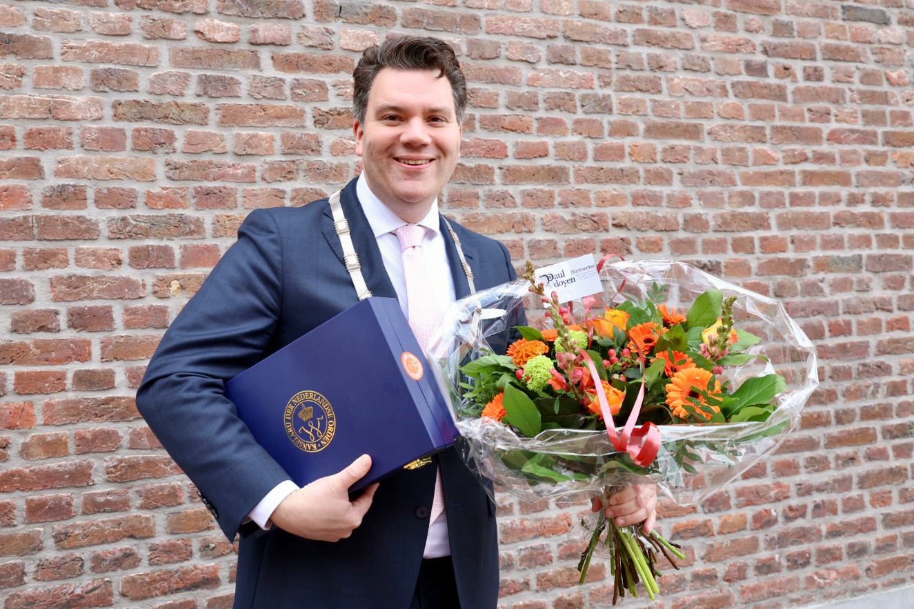 Burgemeester Alain Krijnen met Koninklijke Onderscheiding en bos bloemen